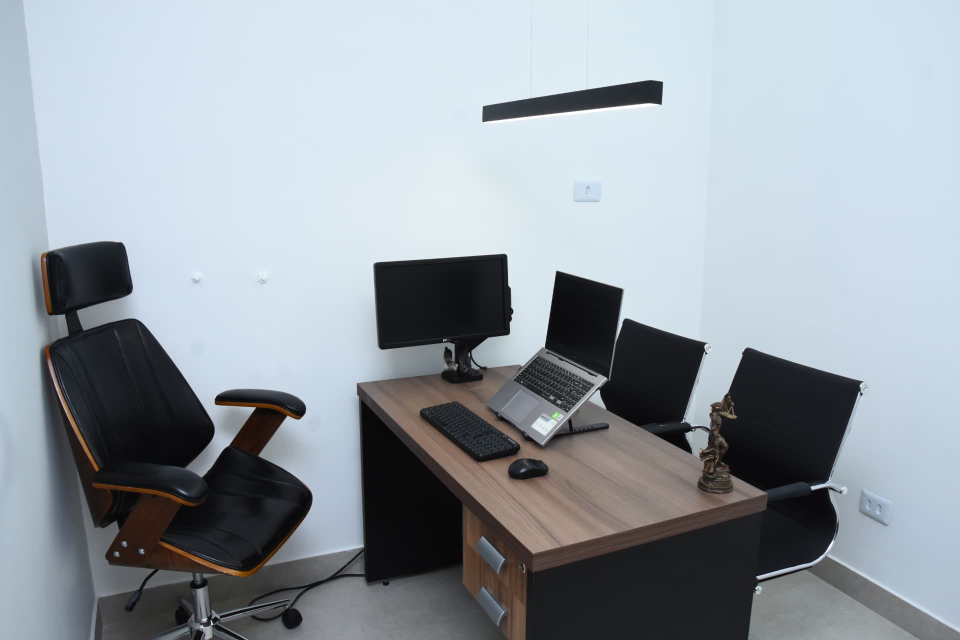 Sala de atendimento individual do escritório, com mesa de trabalho e cadeiras para o cliente